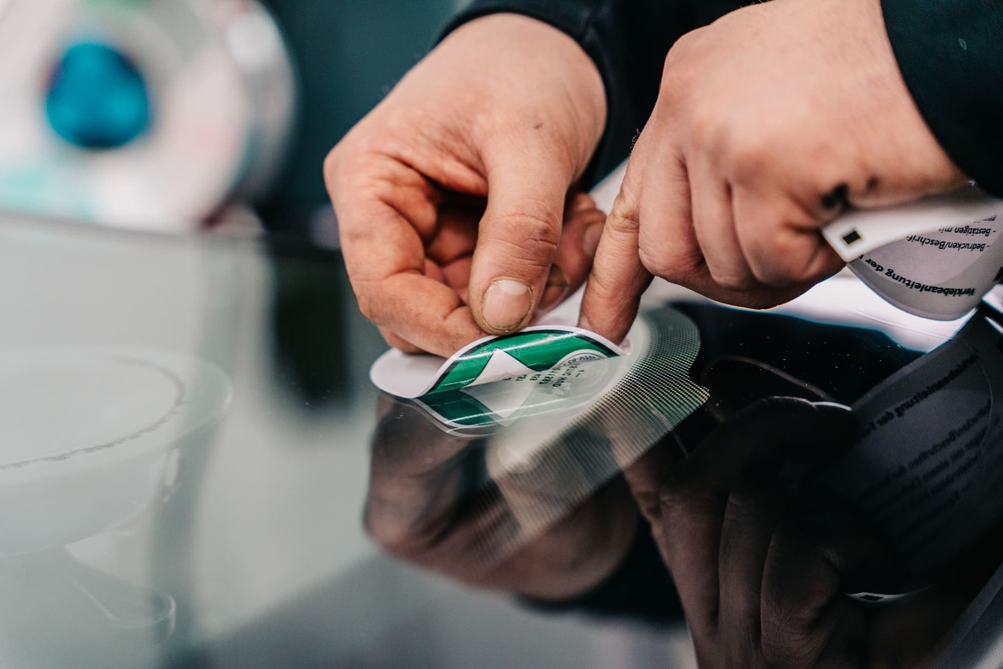 Umweltplakette wird an der neuen Scheibe angebracht
